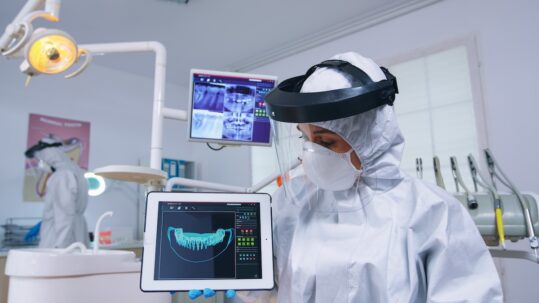Chirurgo implantologo al lavoro con strumenti digitali 3D
